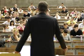 Dozent im Hörsaal mit einer Gruppe Studierenden.